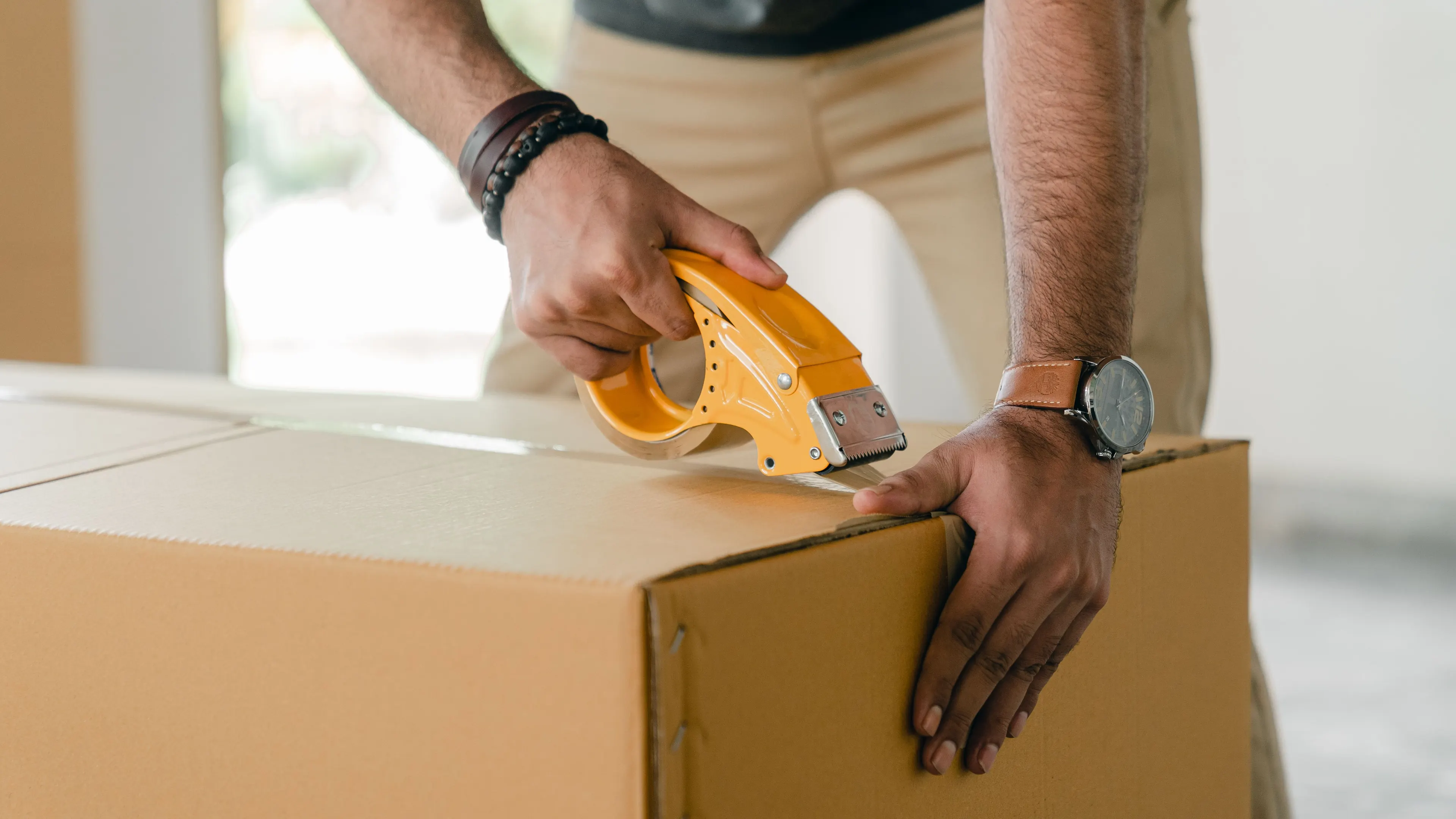 Hands sealing a parcel with packing tape